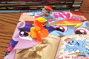 Applejack (front) and Rainbow Dash (back) strut atop posters and books detailing their adventures in Equestria. Their fans are called “bronies.” (Luke Londo/NW) 