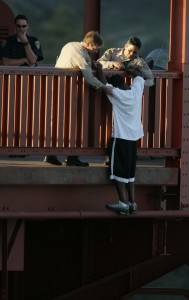 CHP Officer Kevin Briggs helps a jumper over the rail after they talked him down. A jumper, Kevin Berthia, is talked down by CHP officer Kevin Briggs, center, at the north tower of the Golden Gate Bridge. (John Storey: San Francisco Chronicle) 