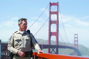 In this photo taken Tuesday, April 30, 2013 California Highway Patrol Sergeant Kevin Briggs poses by the Golden Gate Bridge in San Francisco. About 1,500 people have plunged from the bridge, making it one of the world’s favorite suicide spots.  During his 20 years patrolling the bridge Briggs has managed to talk many despondent people out of taking the fatal fall. (AP Photo/Eric Risberg)